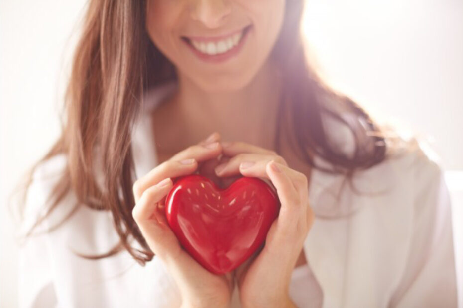 mujer sosteniendo un corazón, que simboliza bondad y amor para uno mismo